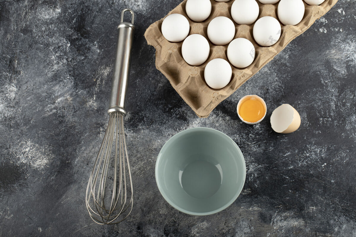 有机白色鸡蛋装在纸箱里 碗和胡须放在大理石表面烹饪食品鸡蛋