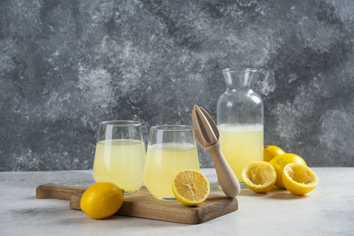 柑橘在木板上放两杯柠檬汁罐子柠檬水桌子