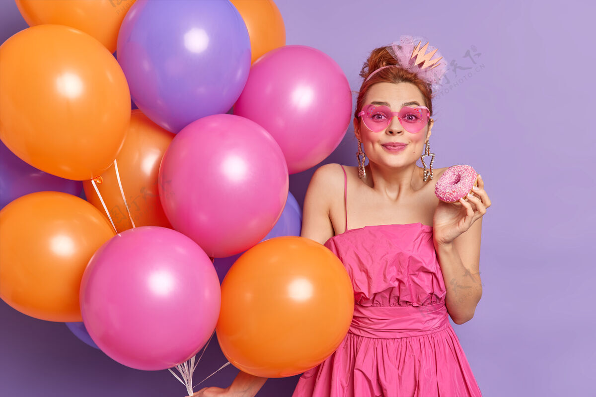 女孩美丽喜庆的红发女青年高兴地看着镜头玩得开心 庆祝节日女性年轻气球