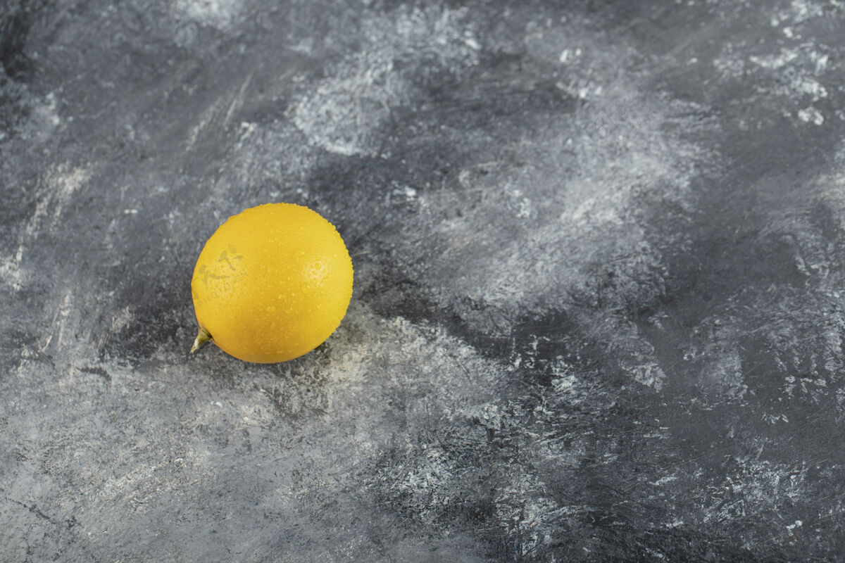 异国情调大理石表面上一个成熟的黄色柠檬切割水果有机