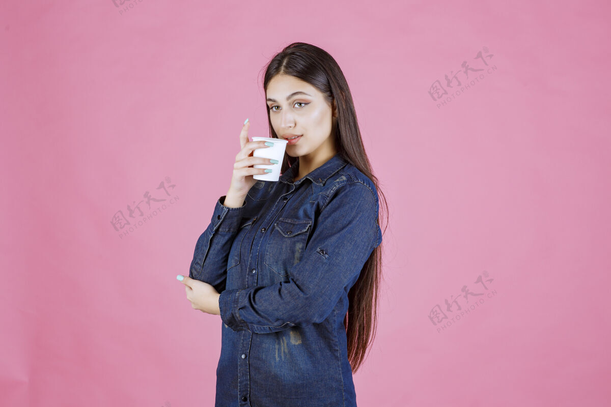 热穿牛仔衫的女孩在喝咖啡女人人类冬天