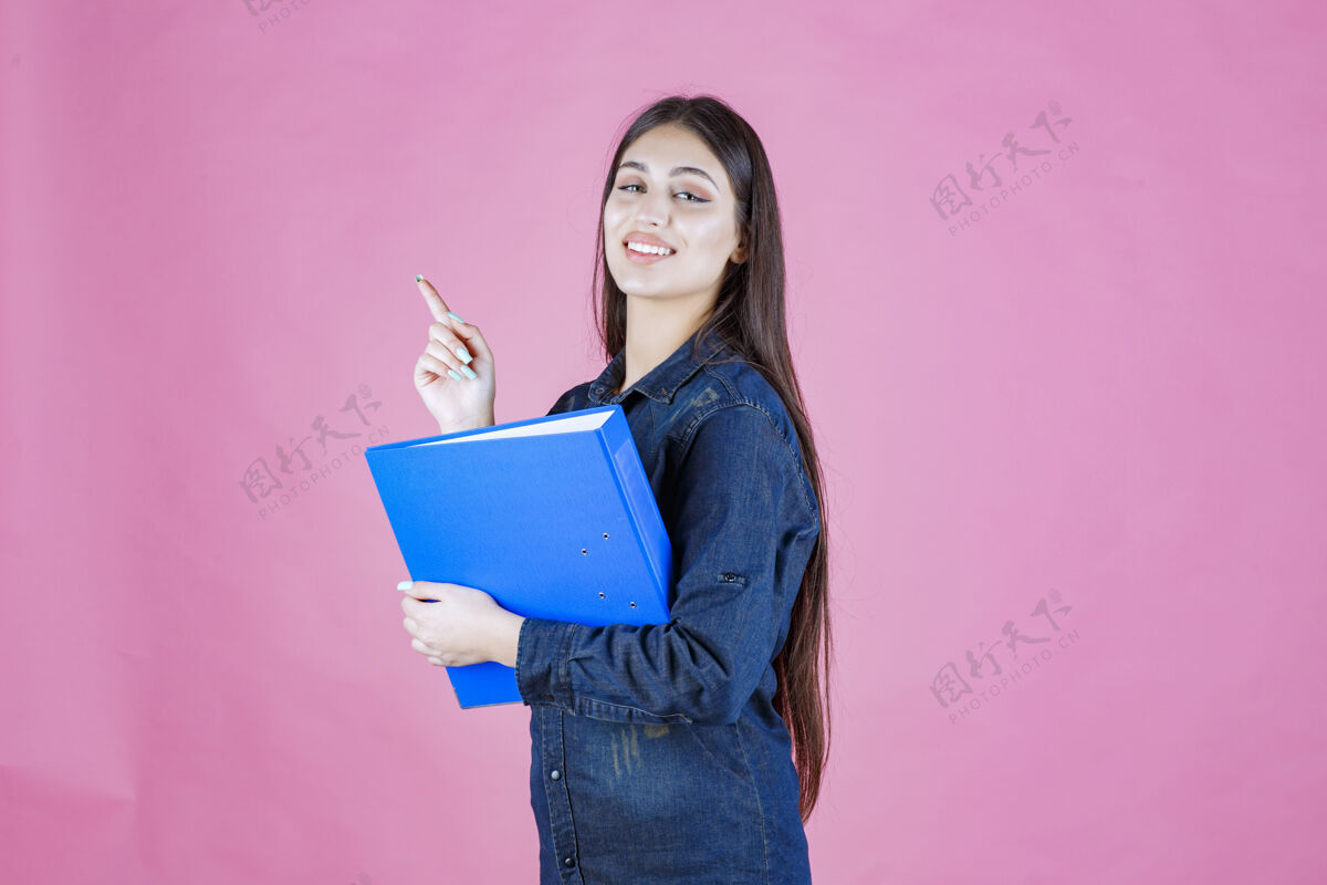 休闲女商人拿着一个蓝色的报告夹 指着上面女性姿势清单