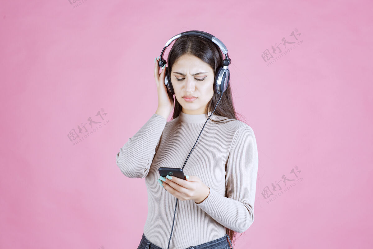 姿势女孩戴着耳机 不喜欢她的音乐播放列表不满意女人名单