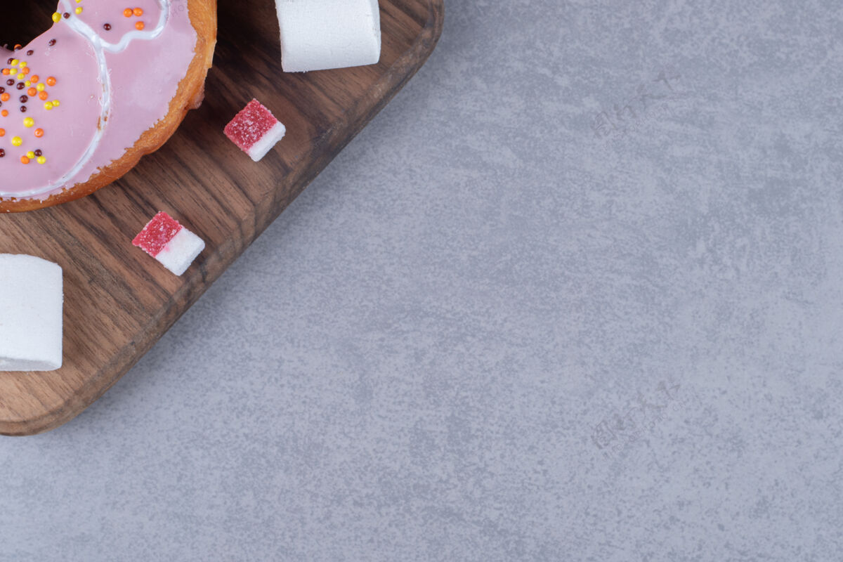 烘焙食品在大理石表面的木板上放一小块果酱 棉花糖和一个甜甜圈美味糕点棉花糖