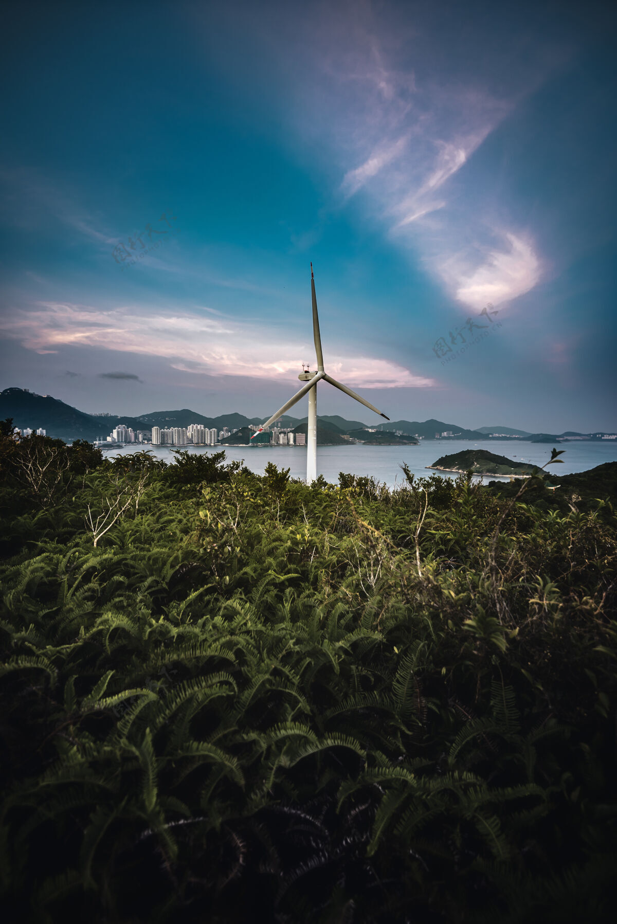 气候一个风轮机的垂直镜头 背景是大海自然风力涡轮机电场