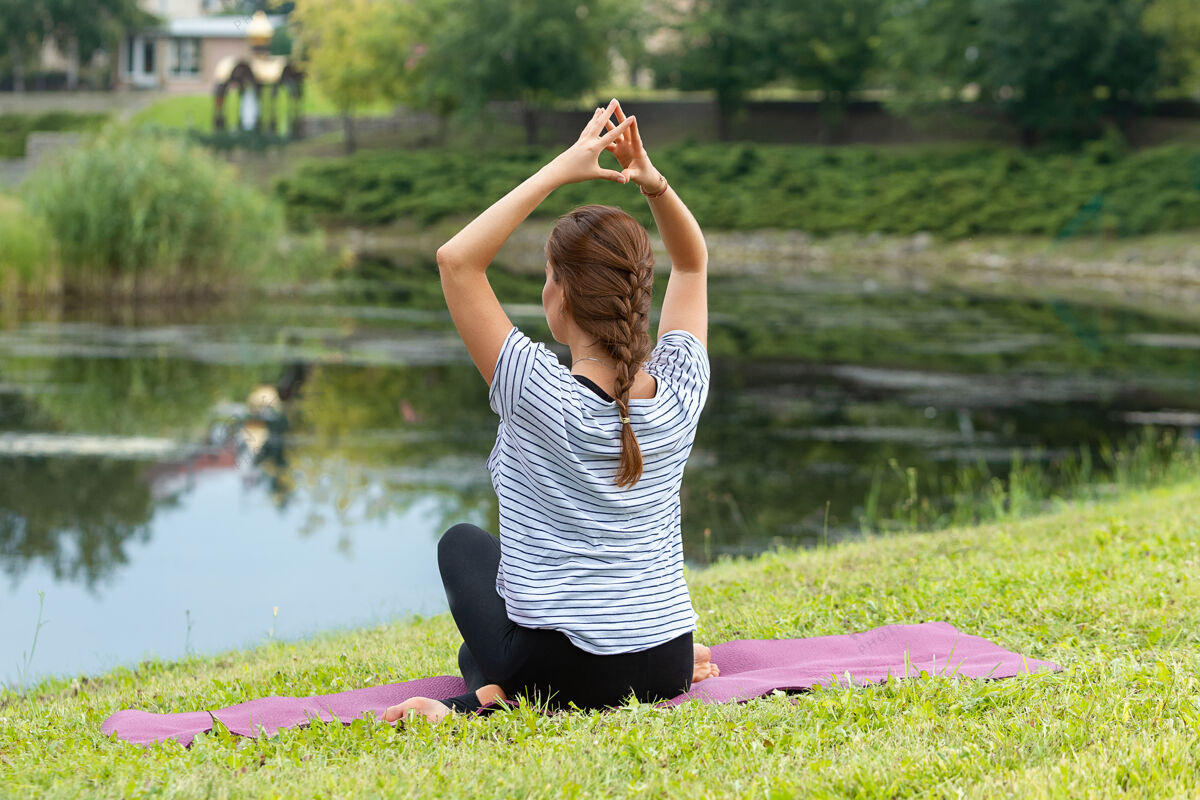 风景年轻漂亮的女人在绿色公园做瑜伽练习宁静放松活力
