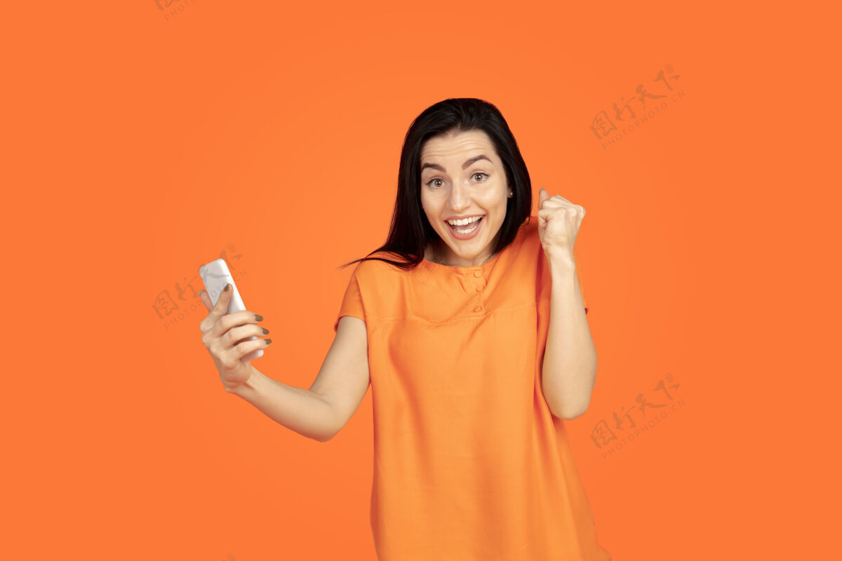 广告橙色背景上的白人年轻女子肖像长度人类员工