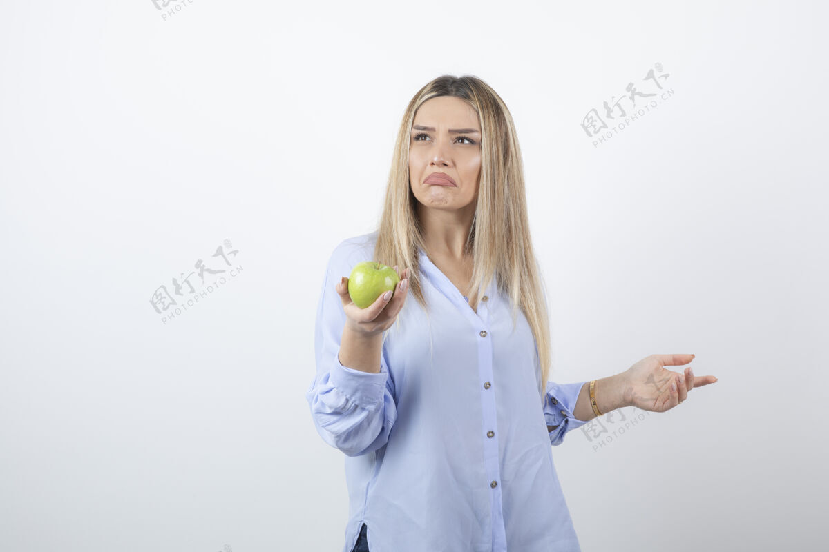 美味一个美丽迷人的女模特站着 手里拿着一个新鲜的绿色苹果的肖像照肖像水果食物