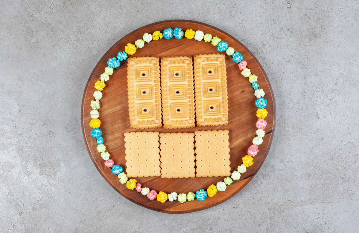 饼干在大理石背景的木板上 饼干被糖果围成一个圈高质量的照片可口糖果美味