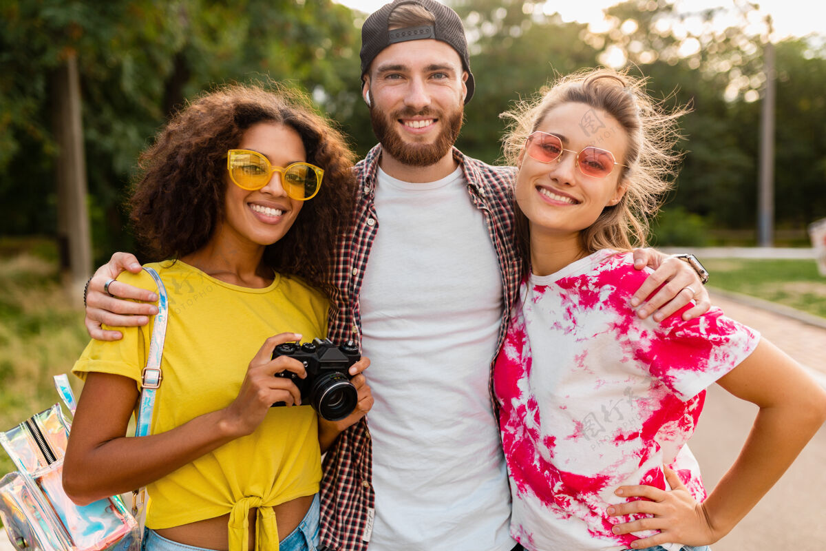 多样性快乐的年轻朋友们带着相机在公园里散步 男女一起玩得很开心积极女人多种族