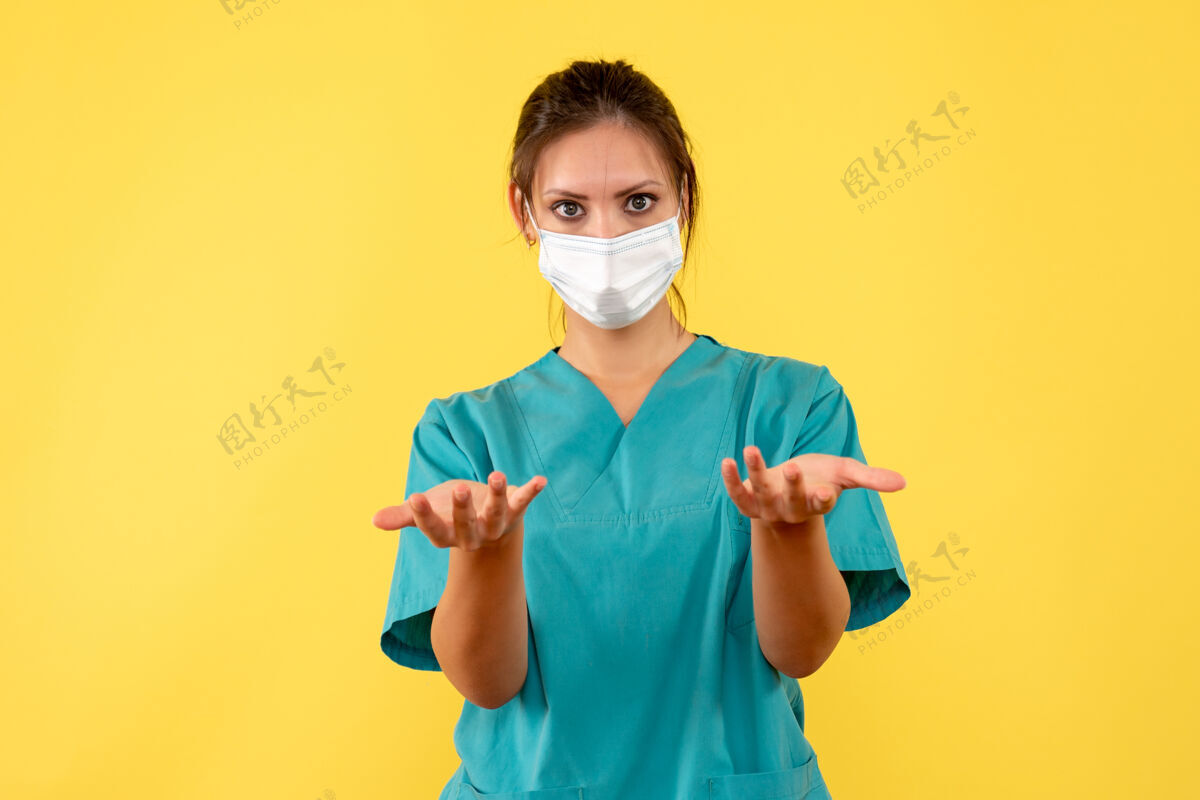 脸正面图黄色背景上穿着无菌口罩医用衬衫的女医生医疗女医生肖像