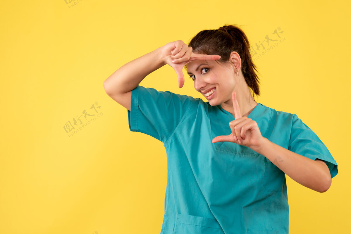 黄色前视图黄色背景上穿着医用衬衫的女医生成人正面医疗
