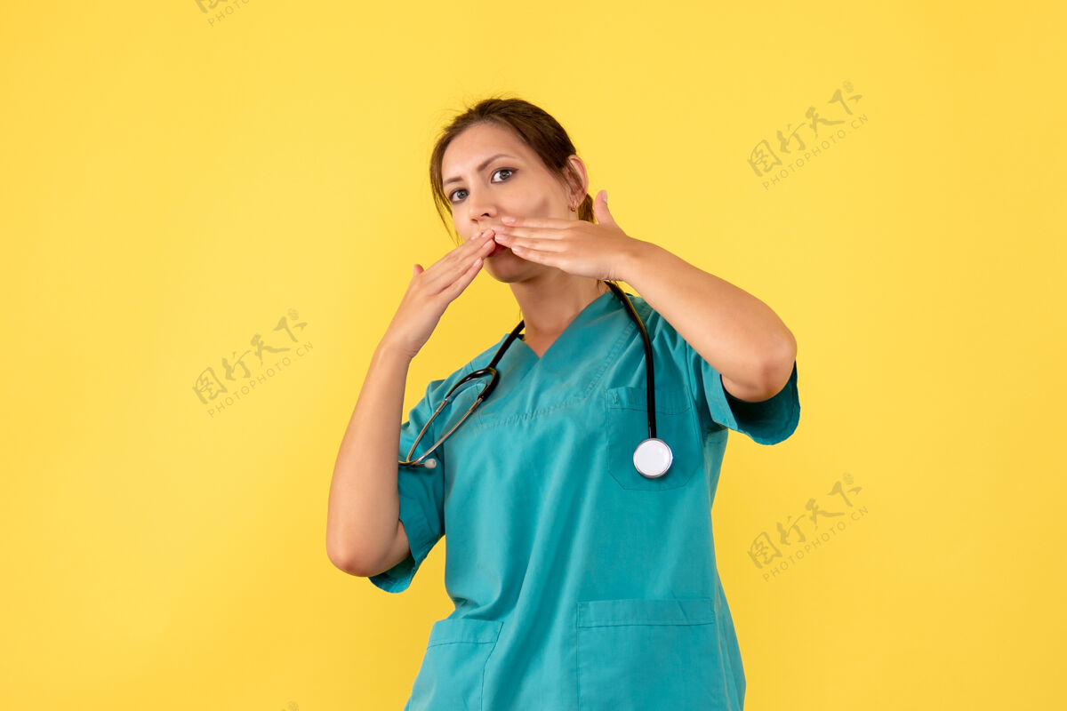 青年前视图黄色背景上穿着医用衬衫的女医生病毒正面情绪