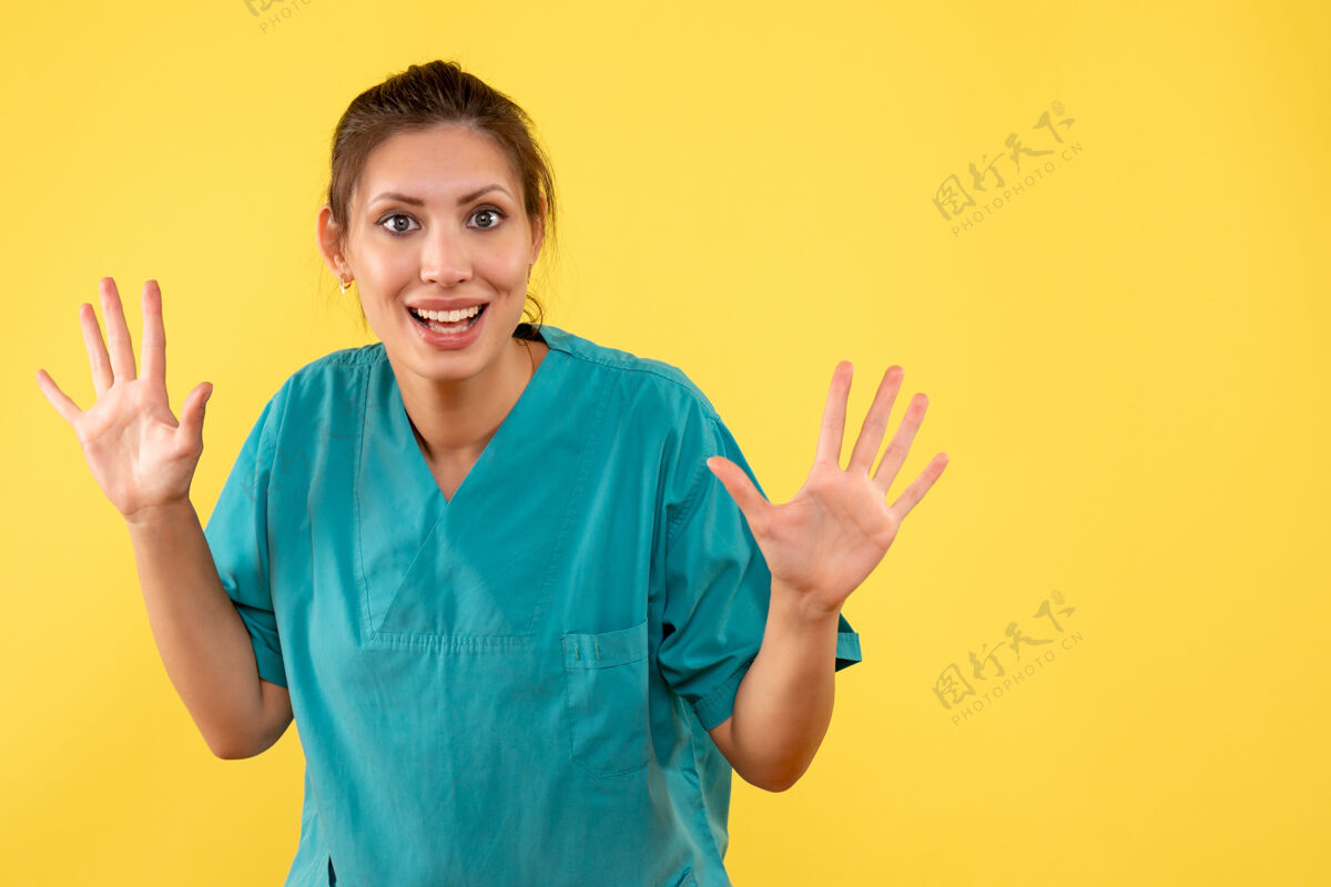 医疗前视图黄色背景上穿着医用衬衫的女医生手持视图健康