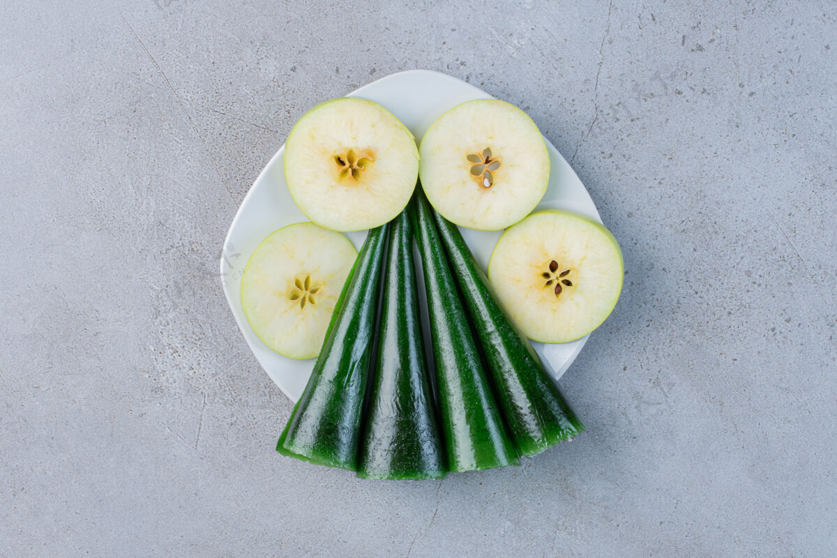 水果苹果片和苹果味的酸味小吃放在大理石背景的盘子里美味饮食健康