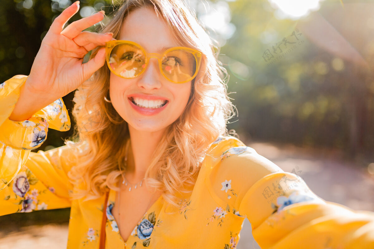 街头美丽的金发时尚微笑的黄色女衬衫戴墨镜自拍照片的肖像眼镜欢呼时尚