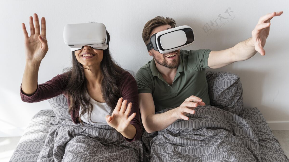 床在床上使用虚拟现实耳机的笑脸女人和男人的前视图男人女人房子
