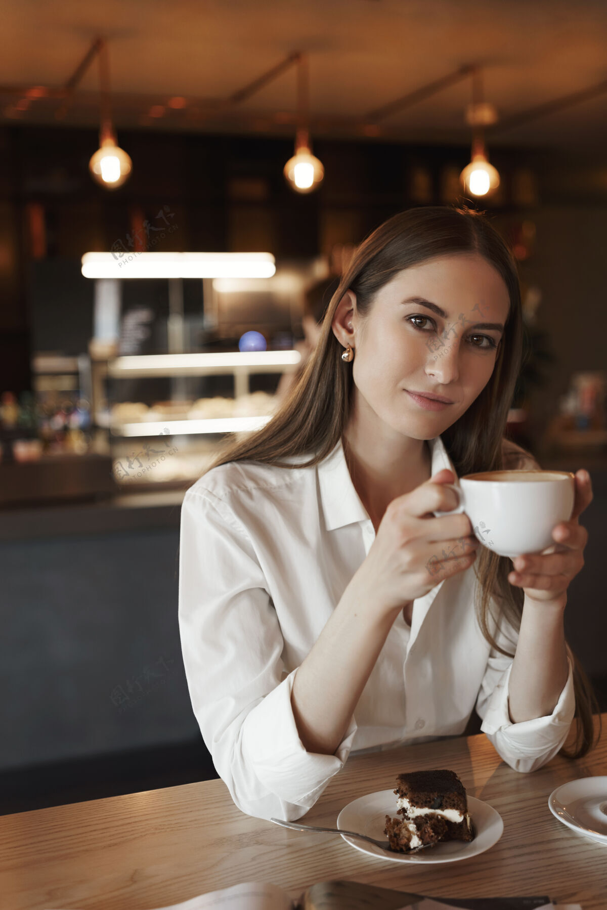 年轻浪漫的女性年轻女子独自在舒适的咖啡馆里喝咖啡的垂直肖像员工蛋糕商务女性