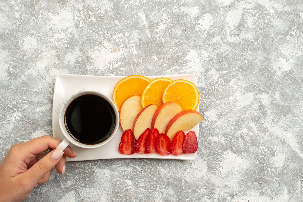 顶部俯瞰一杯咖啡 苹果片 橙子和草莓 背景为白色 果味清新醇厚醇香的杯子马克杯