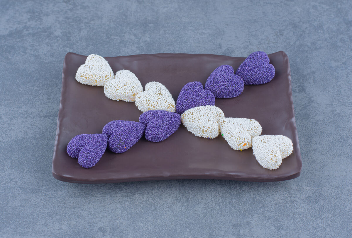 不健康紫色和白色的饼干在黑板上 在大理石背景上配料美味糕点