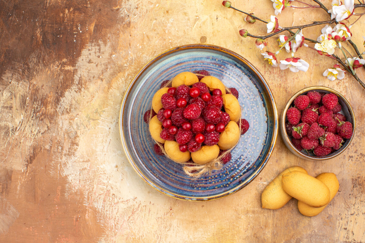 碗上图：混色桌上新鲜出炉的水果和饼干软蛋糕健康食品浆果