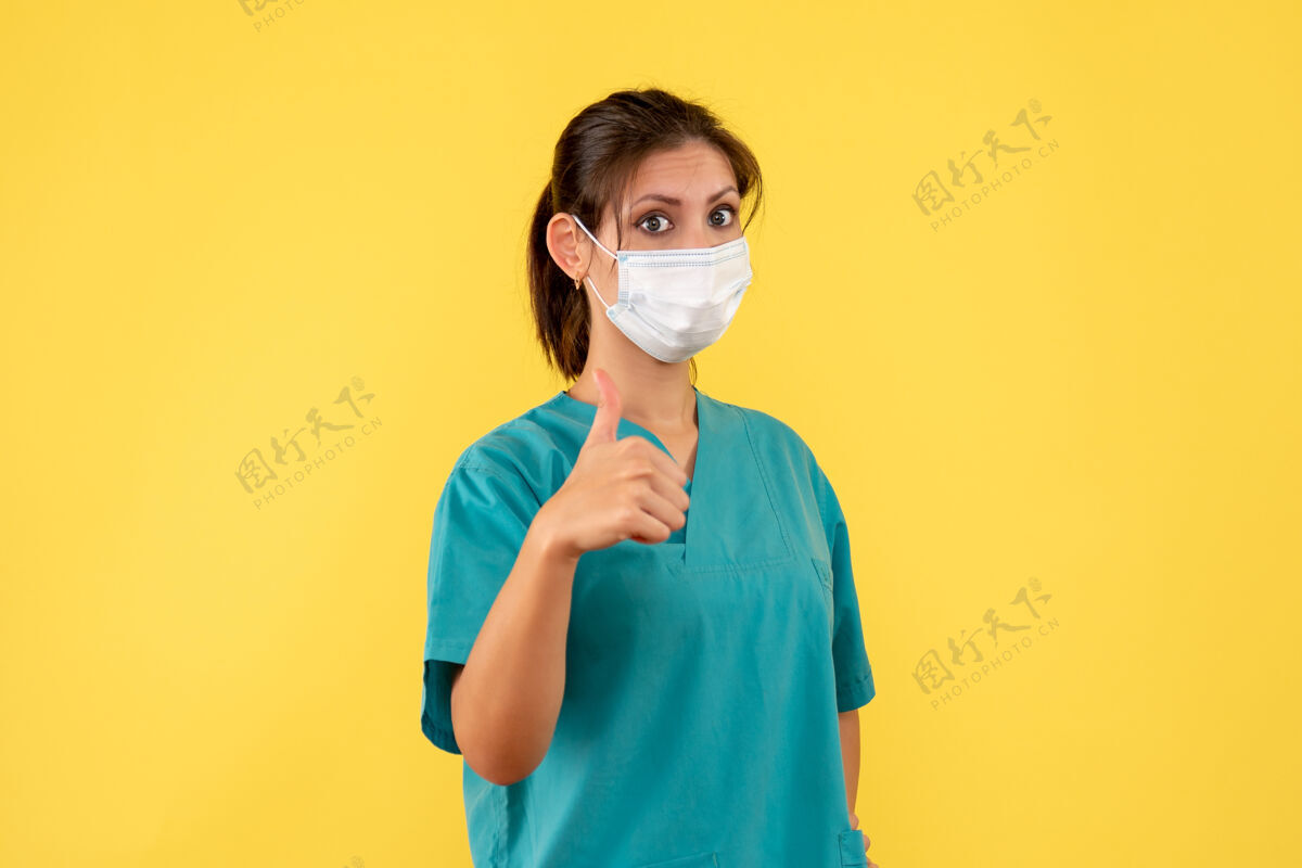 女医生前视图黄色背景上穿着医用衬衫和面罩的女医生成人视图脸