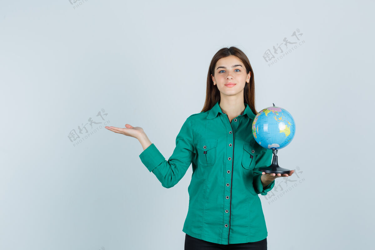 衬衫穿着衬衫的年轻女士举着地球仪 做着欢迎的手势 看上去很高兴 前视图女士举行漂亮