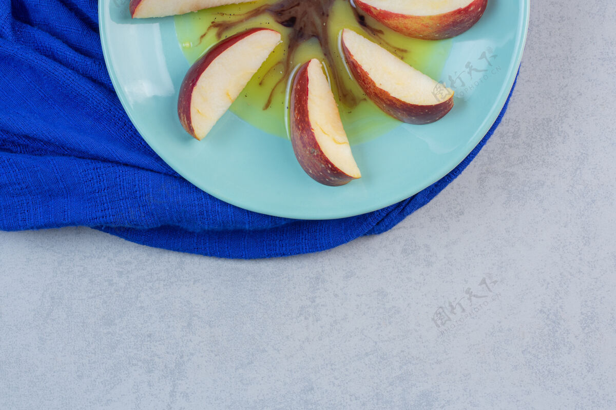种子把红黄苹果片放在蓝盘子里明亮营养健康