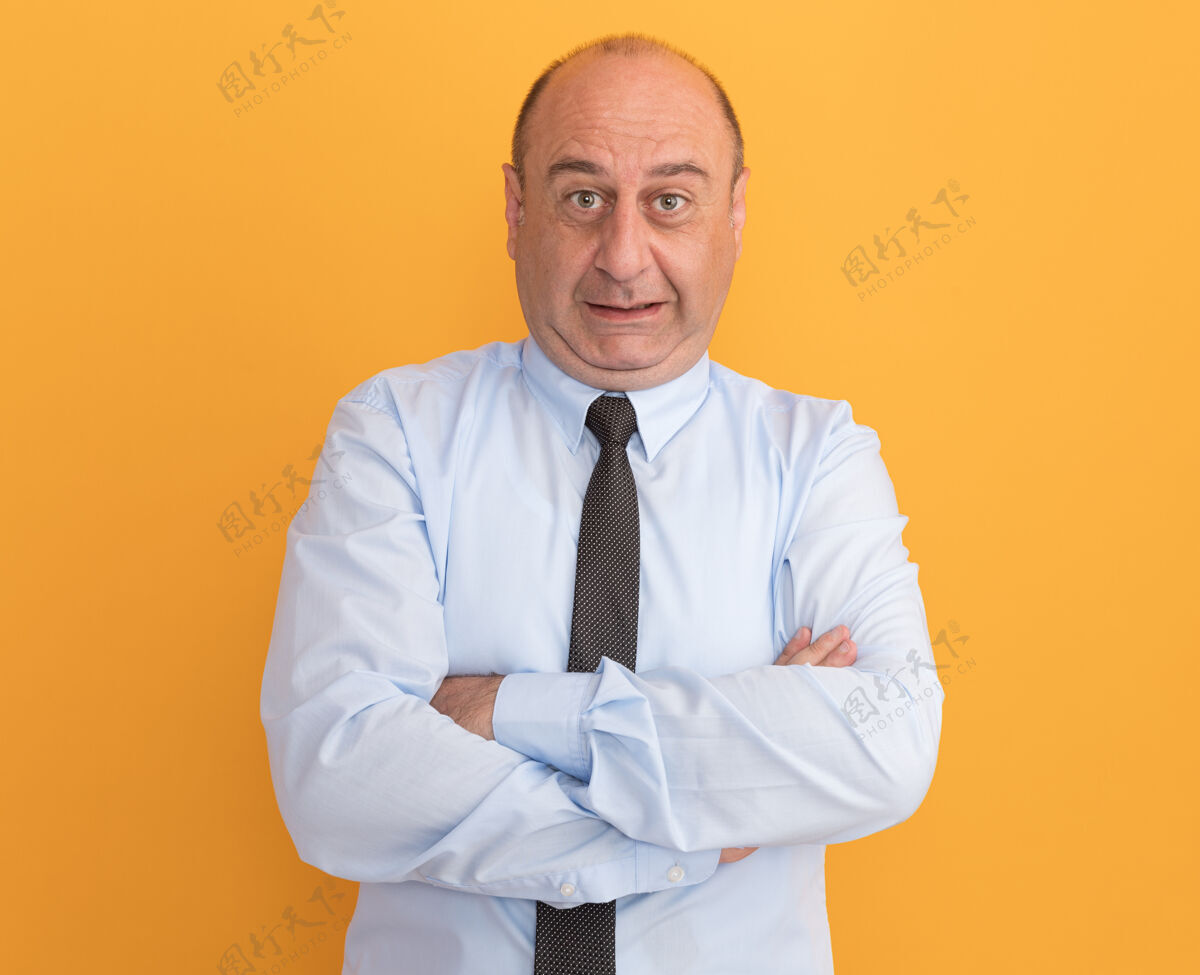 穿一位身穿白色t恤 双手交叉打着领带的中年男子孤零零地站在橙色的墙上十字架T恤手