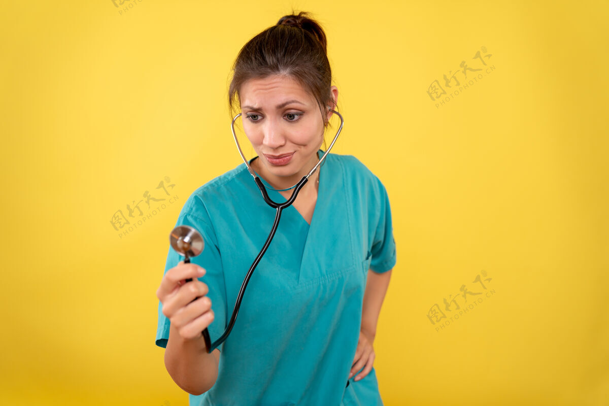 药品正面图黄色背景 穿着医用衬衫 带听诊器的女医生视图医生病毒