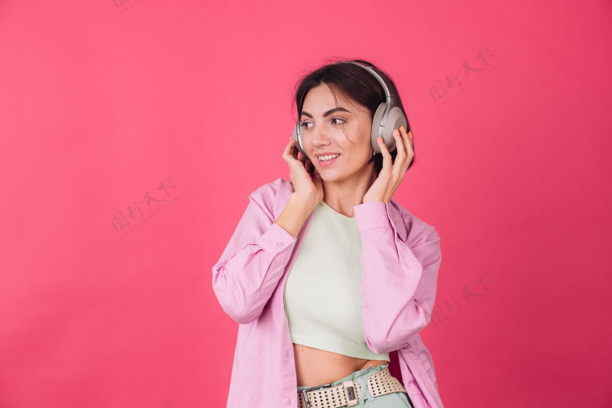 脸粉红红墙上戴着耳机的快乐积极的女人女士女性无线