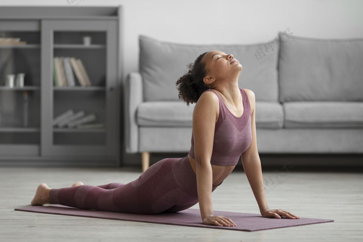 姿势健身女士在家里用瑜伽垫做瑜伽企业健康灵活