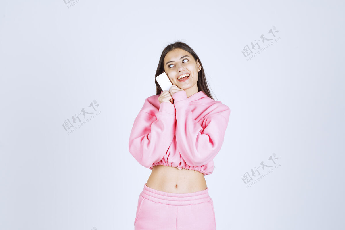 休闲穿着粉色睡衣的女孩拿着名片向她的商业伙伴介绍自己人力量服装