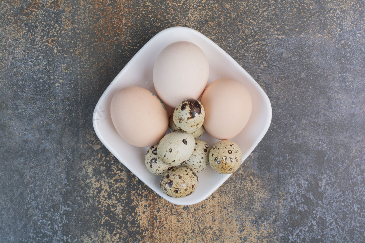 自然鸡和鹌鹑蛋放在白碗里顶视图鹌鹑鸡肉