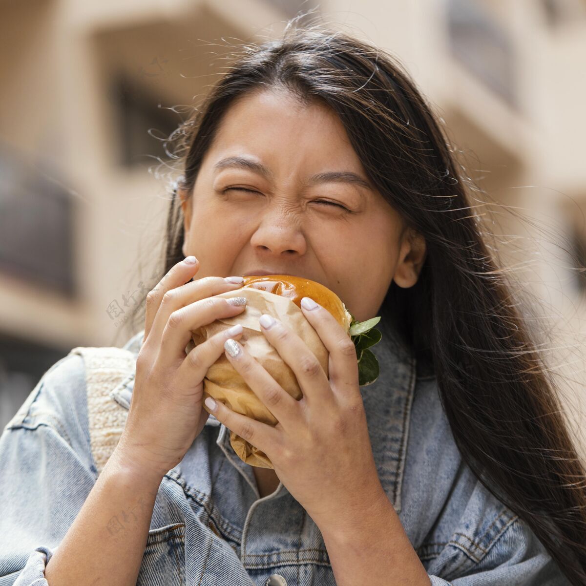食物快乐的亚洲女人在户外吃汉堡垃圾食品街头食品美味