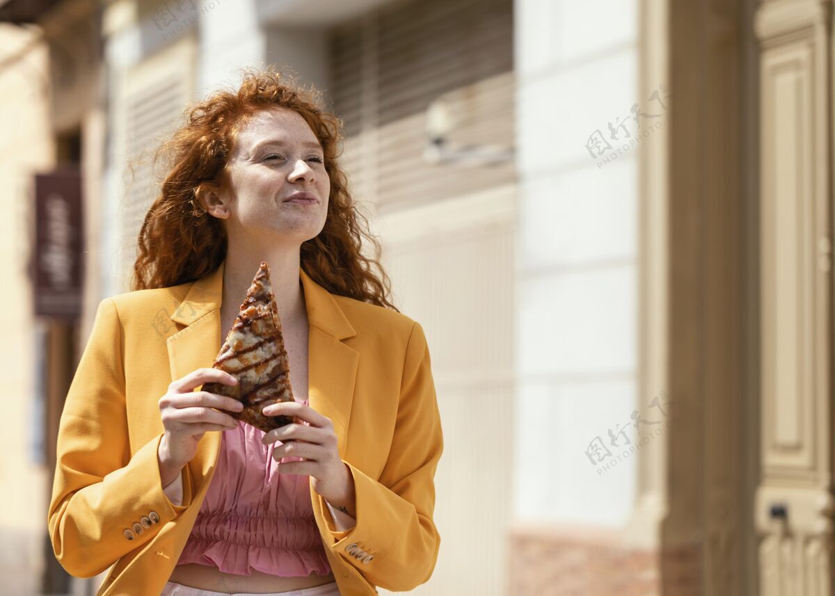 顾客红发女人在吃街上的食物街头食品垃圾食品美味
