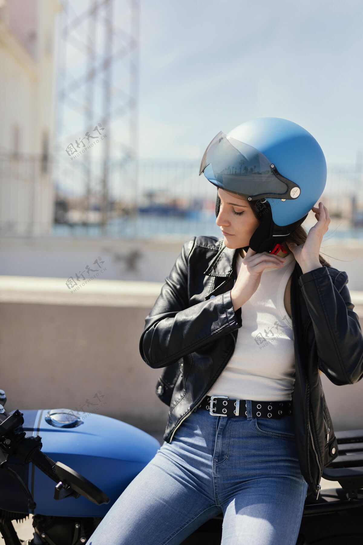 摩托车准备在城里骑摩托车的年轻女子头盔旅行女人