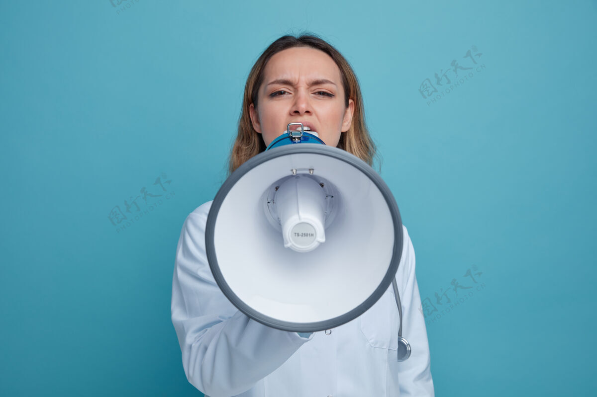蓝色愁眉不展的年轻女医生穿着医用长袍 脖子上戴着听诊器说话的演讲者医疗脖子穿