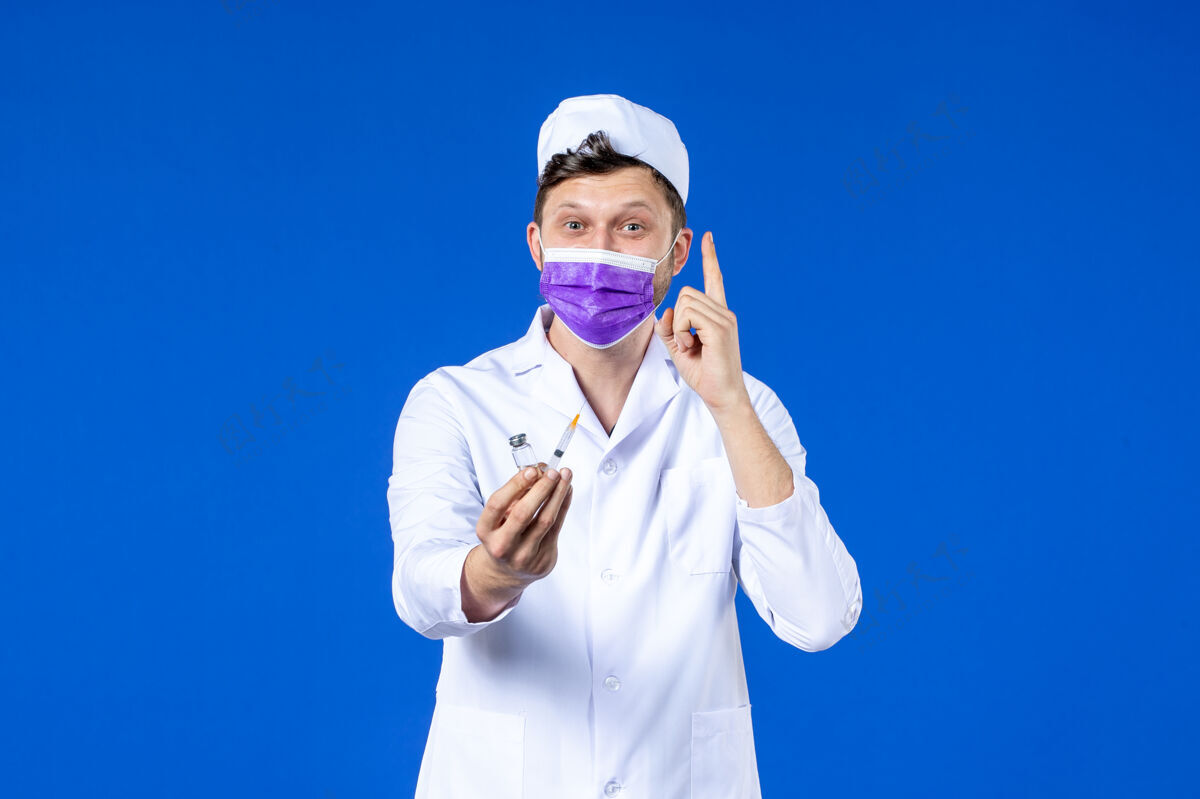 工作服男医生的前视图 穿着医疗服 戴着蓝色的注射和疫苗面罩疫苗医院男医生