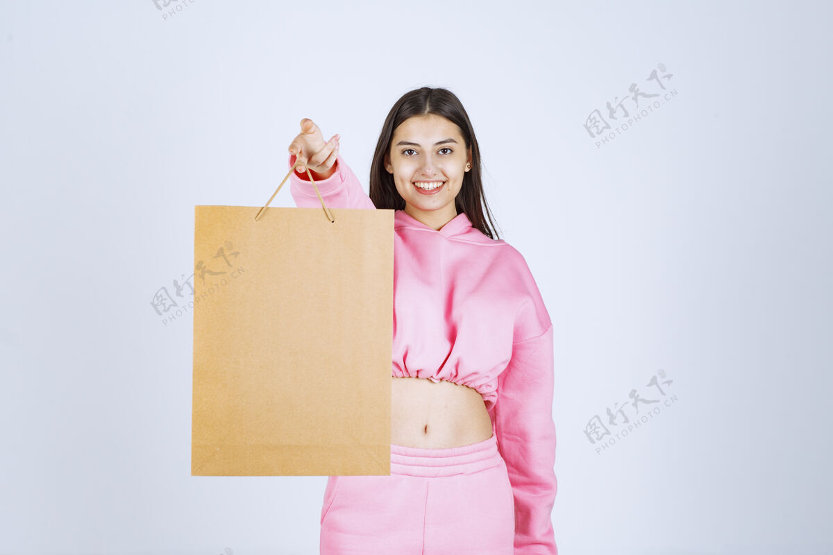 摄影一个女孩拿着一个纸板购物袋递给顾客休闲销售工人