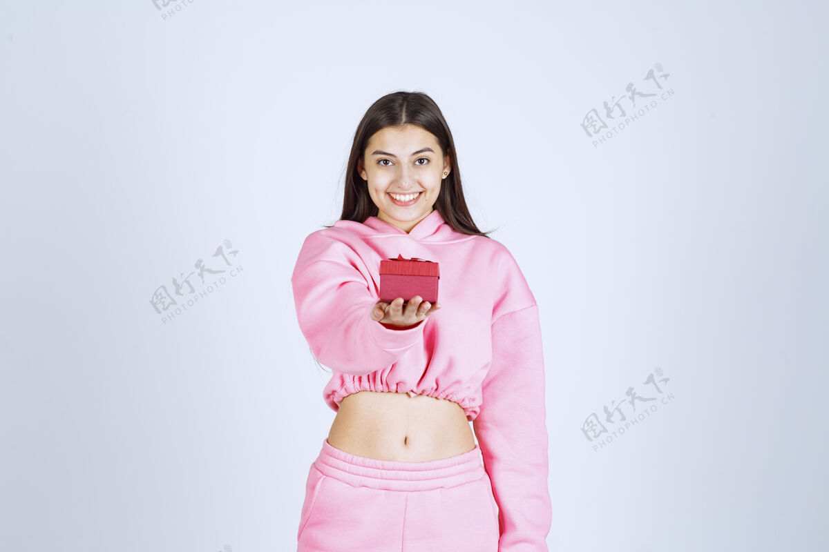 女人穿着粉色睡衣的女孩拿着一个红色的小礼盒送给她的朋友人类年轻人体模型