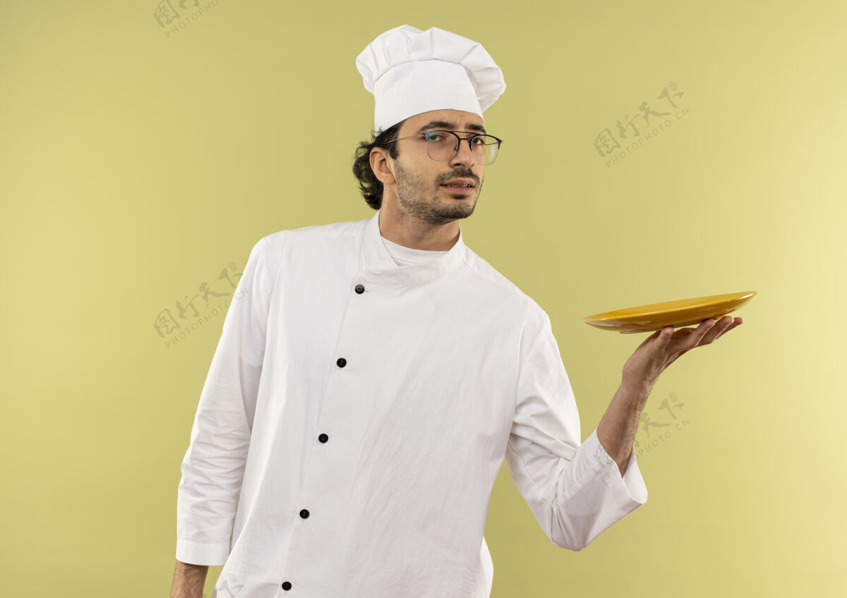 制服年轻的男厨师穿着厨师制服 戴着眼镜拿着盘子年轻烹饪男性