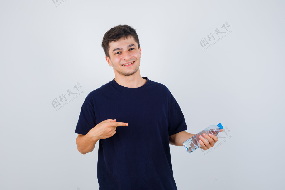 帅气照片中的年轻人指着一瓶水 穿着黑色t恤 看上去很自信人男人现代