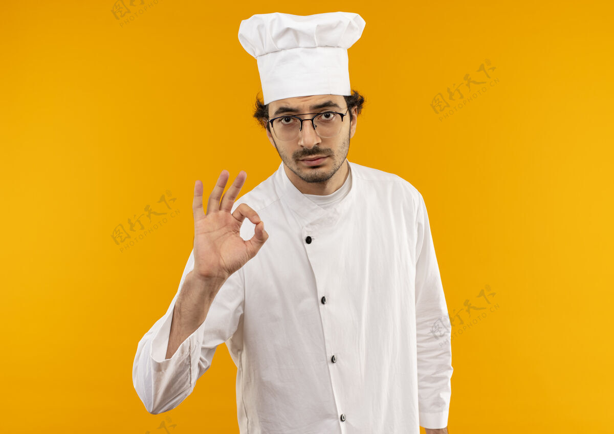 男性年轻的男厨师穿着厨师制服 戴着眼镜 摆出一副很好的姿势眼镜烹饪年轻
