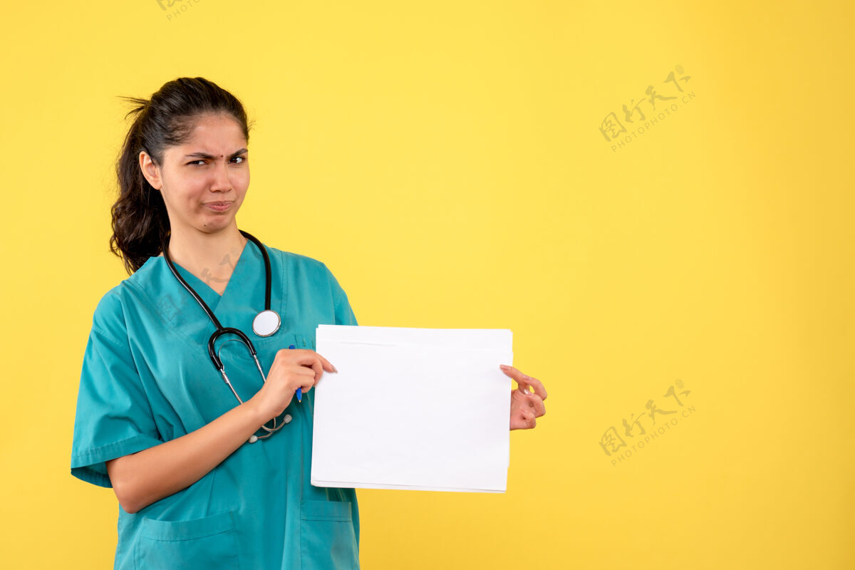 医院前视图困惑的女医生拿着黄色背景的文件肖像前面医生