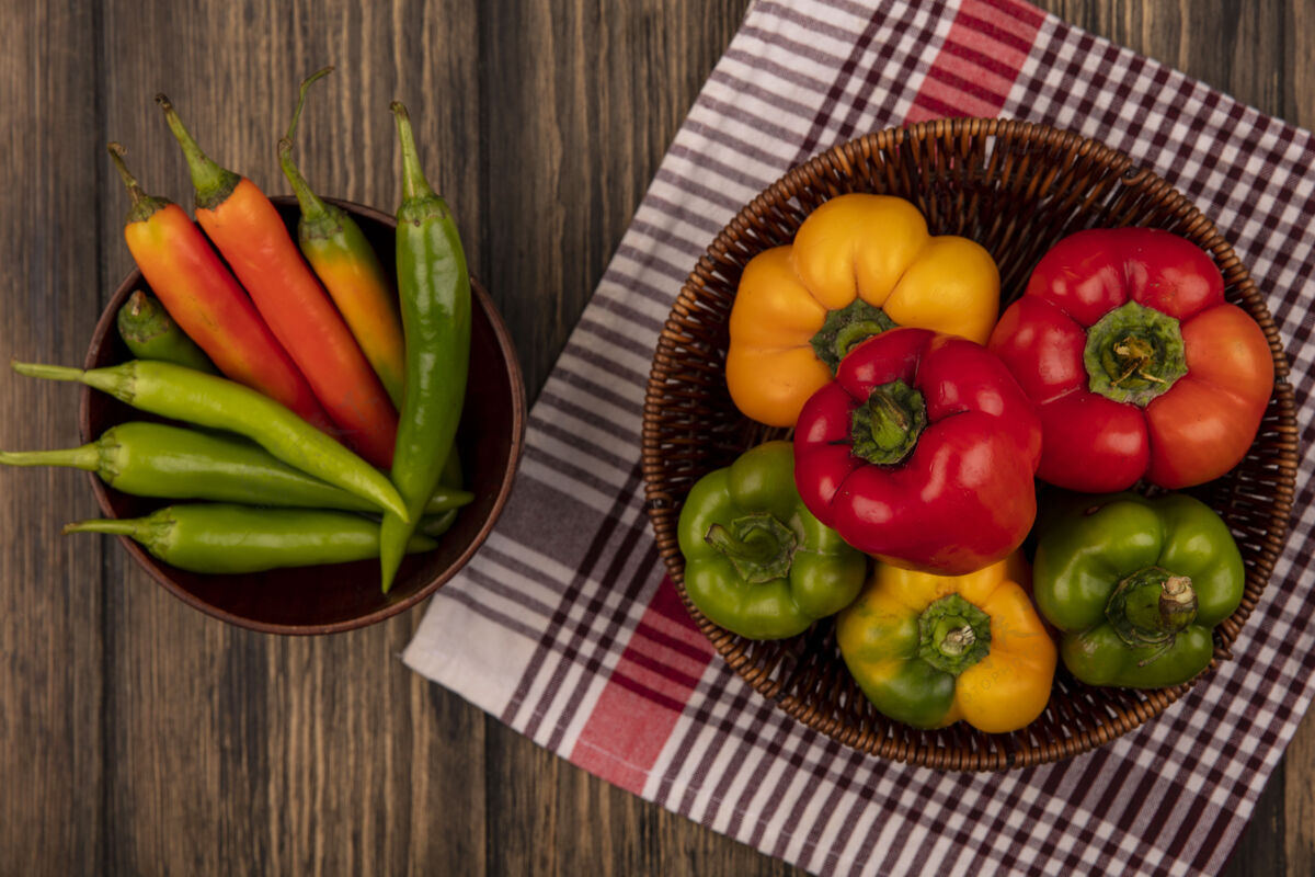 饭新鲜五颜六色的甜椒在一个格子布桶上的顶视图与长形青椒在一个木制表面碗美味衣服饮食