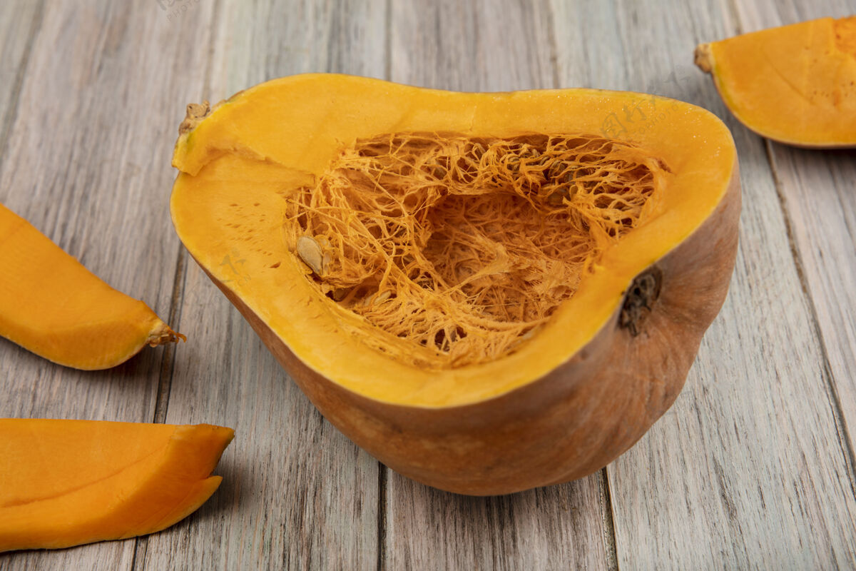 传统橙色营养南瓜的顶视图 它的种子和南瓜皮被隔离在一个灰色的木制表面上庆祝饮食健康