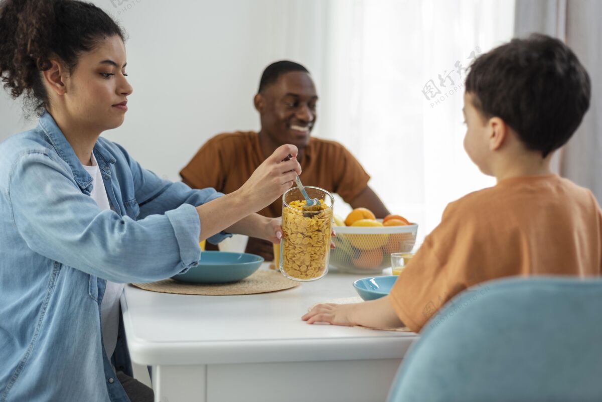 家庭快乐的黑人家庭 母亲为孩子服务快乐的家庭家庭早餐人