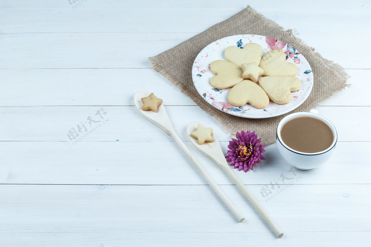 招待高角度观看心形饼干 一杯带花的咖啡 白色木板背景上的木勺星形饼干水平甜点小吃自制