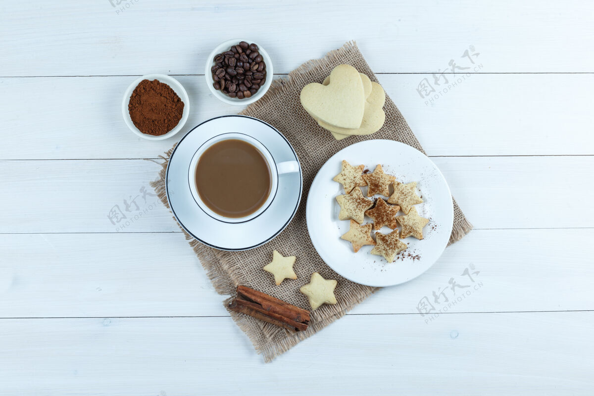 肉桂一套曲奇饼 肉桂棒 咖啡豆 磨碎的咖啡和咖啡在一个木杯和一块布袋背景顶视图豆子袋子自然
